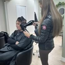 A girl getting her hair blow dried
