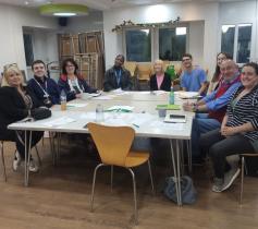 Group of people sat at a table with worksheets in front of them mid training course