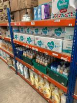 Industrial shelving stocked with donated household essentials including nappies, baby wipes, fabric conditioner, and cleaning products, arranged in a tidy warehouse storage area.